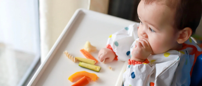 Baby feeding himself in baby led weaning